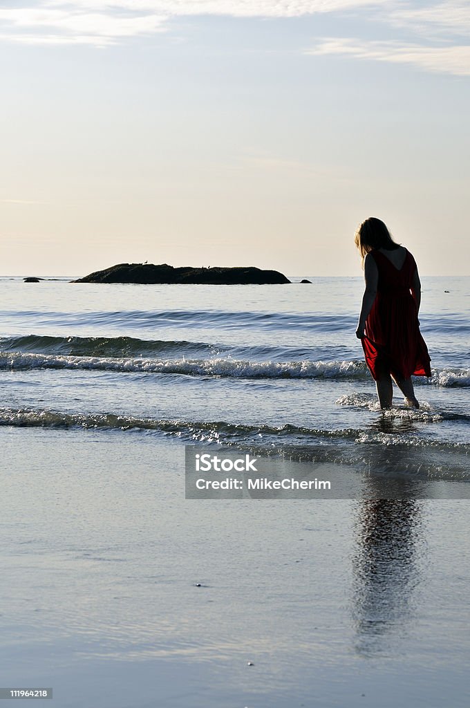 Silhouetted BIONDO cammina nel Surf - Foto stock royalty-free di 20-24 anni