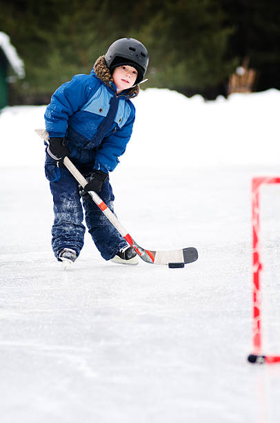 istock young boy playing hockey outdoors 111964761