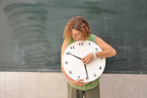 Red alarm clock with colored papers and quiz text on blue background