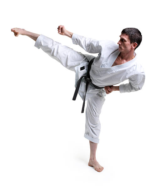 Karate. Man in a kimono hits foot stock photo