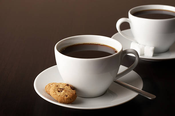 Two cups of coffee with a cookie and sugar cubes stock photo