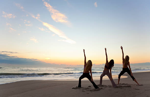 istock Three women practicing yoga on the beach 112136967