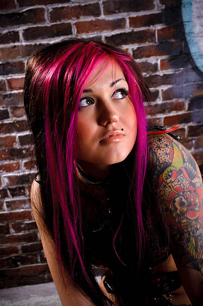 istock Attractive tattooed girl studio portrait, brick wall at backgrou 112144023