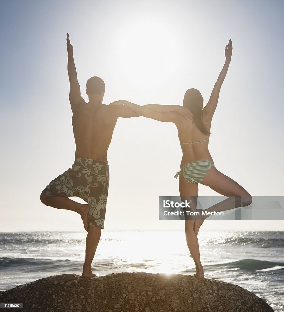 Equilibrio sobre un par de pie juntos en la playa - Foto de stock de Agarrados del brazo libre de derechos