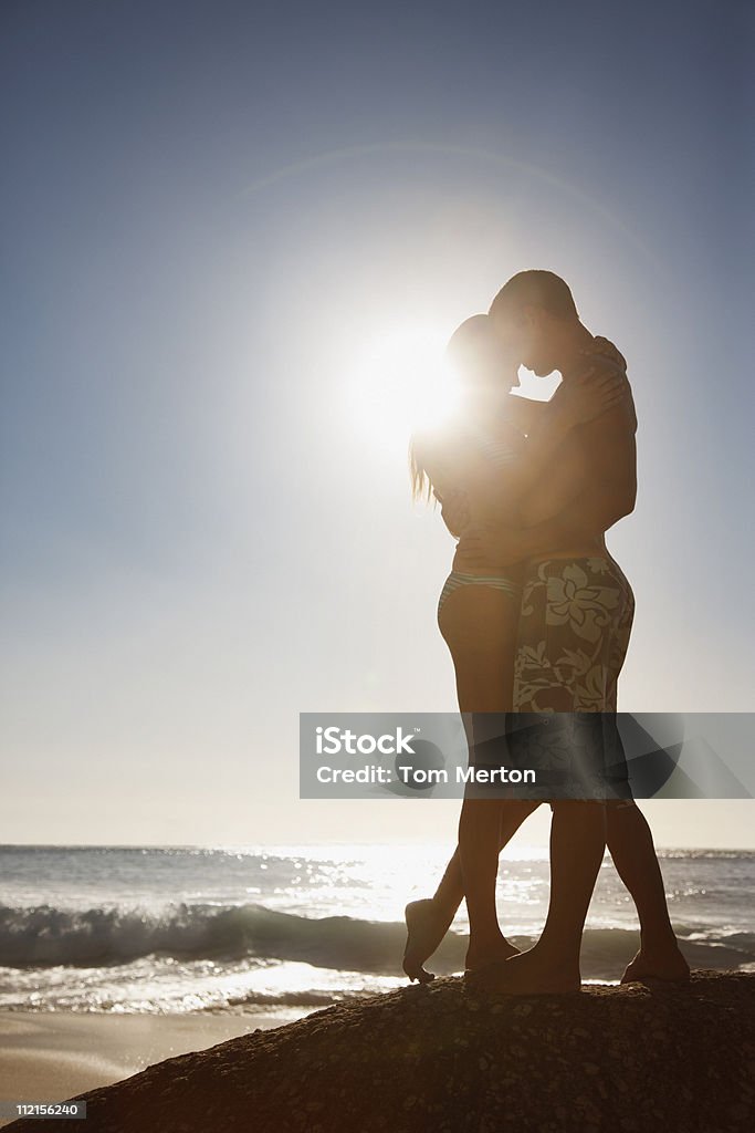 커플입니다 껴안기 on 바위산 니어 해양수 - 로열티 프리 실루엣 스톡 사진