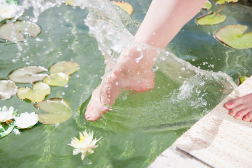 A water stream running over 2 couple of hands allowing them to feel the freshness of the water