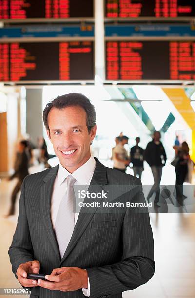 Foto de Empresário De Mensagens De Texto No Telefone Celular No Aeroporto e mais fotos de stock de 40-44 anos