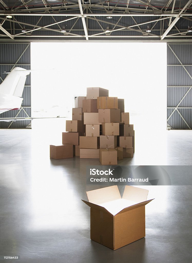 Pila di scatole in hangar - Foto stock royalty-free di Scatola