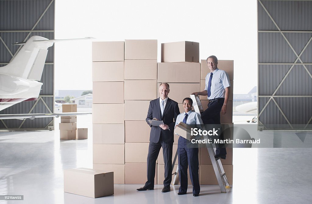 Supervisor e trabalhadores em pé perto de caixas em hangar - Royalty-free Homens Foto de stock