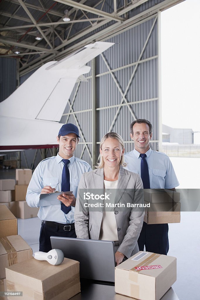 Supervisor y de los trabajadores de pie con cajas en el hangar - Foto de stock de Oficio libre de derechos