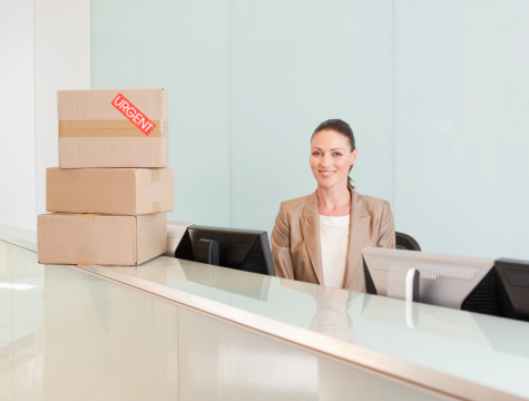 Midsection of unrecognizable businesswoman standing at the office, holding a box with her belongings and office supplies, fired, looking for a new job.