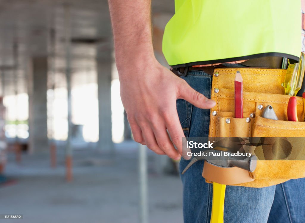 Primer plano de trabajadores de la construcción en sitio de construcción de cinturón de herramientas - Foto de stock de 20-24 años libre de derechos