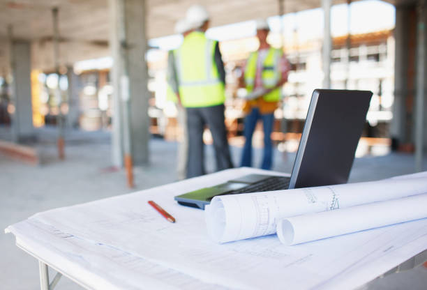 operários atrás de plantas e laptop em constructio - building interior - fotografias e filmes do acervo