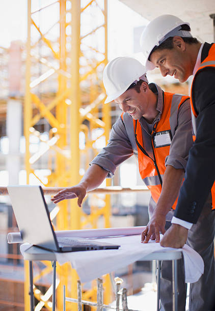 bau arbeiter mit laptop auf baustelle - building contractor computer internet construction worker stock-fotos und bilder