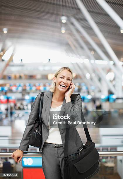 Businesswoman Talking On Cell Phone In Office Stock Photo - Download Image Now - Airport, Business, Business Travel