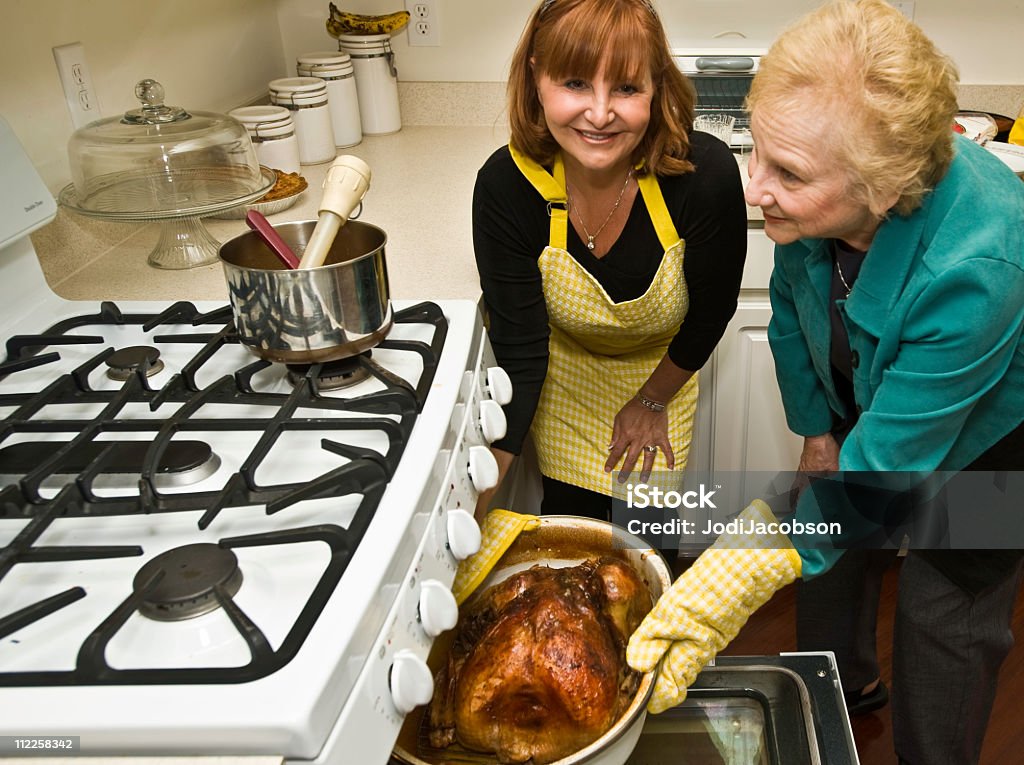 Mãe e filha fazendo uma Turquia fora do forno - Foto de stock de Peru - Carne Branca royalty-free