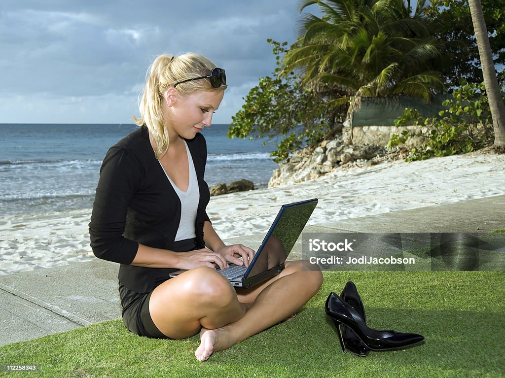 女性のビーチでのコンピューター - コンピュータのロイヤリティフリーストックフォト