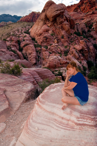 woman feeling sadness, depression and sorrow. She went to a beautiful place in Red rock state park nevada, to think about life and sort things out.