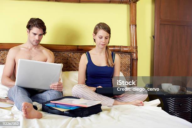 Junges Paar Von Zu Hause Mit Pc Stockfoto und mehr Bilder von Paar - Partnerschaft - Paar - Partnerschaft, Schlafanzug, Telearbeit