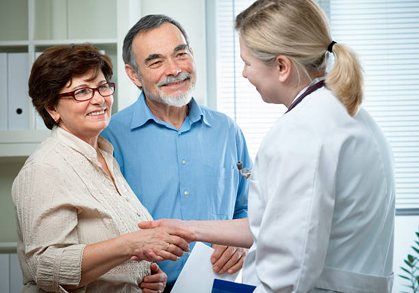 presso l'ufficio del medico - discussion couple senior adult inside of foto e immagini stock