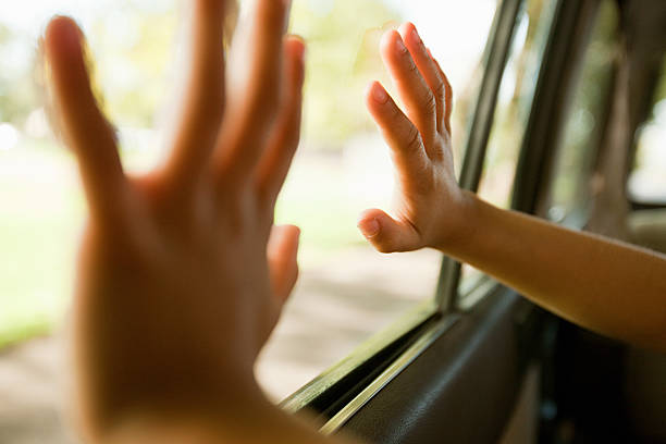 enfant mains toucher fenêtre de la voiture - stuck photos et images de collection