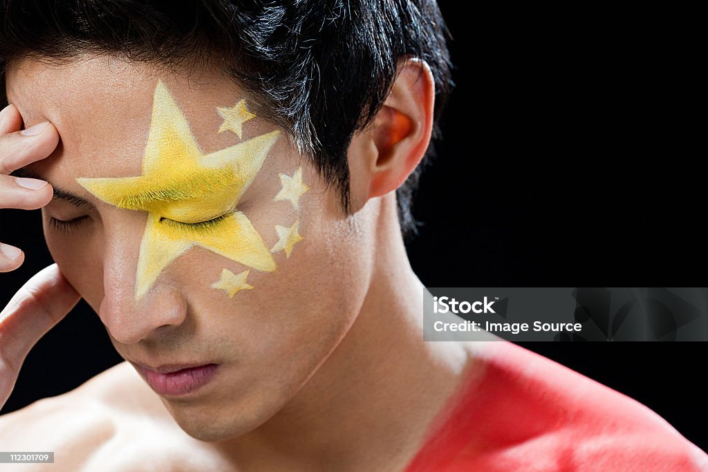 Hombre con bandera china pintado en el rostro y hombro - Foto de stock de 20-24 años libre de derechos