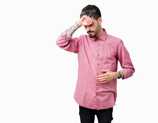 istock Young handsome man wearing pink shirt over isolated background Touching forehead for illness and fever, flu and cold, virus sick 1124220551