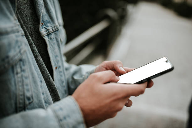 istock Young man at city street using a smartphone 1124221448