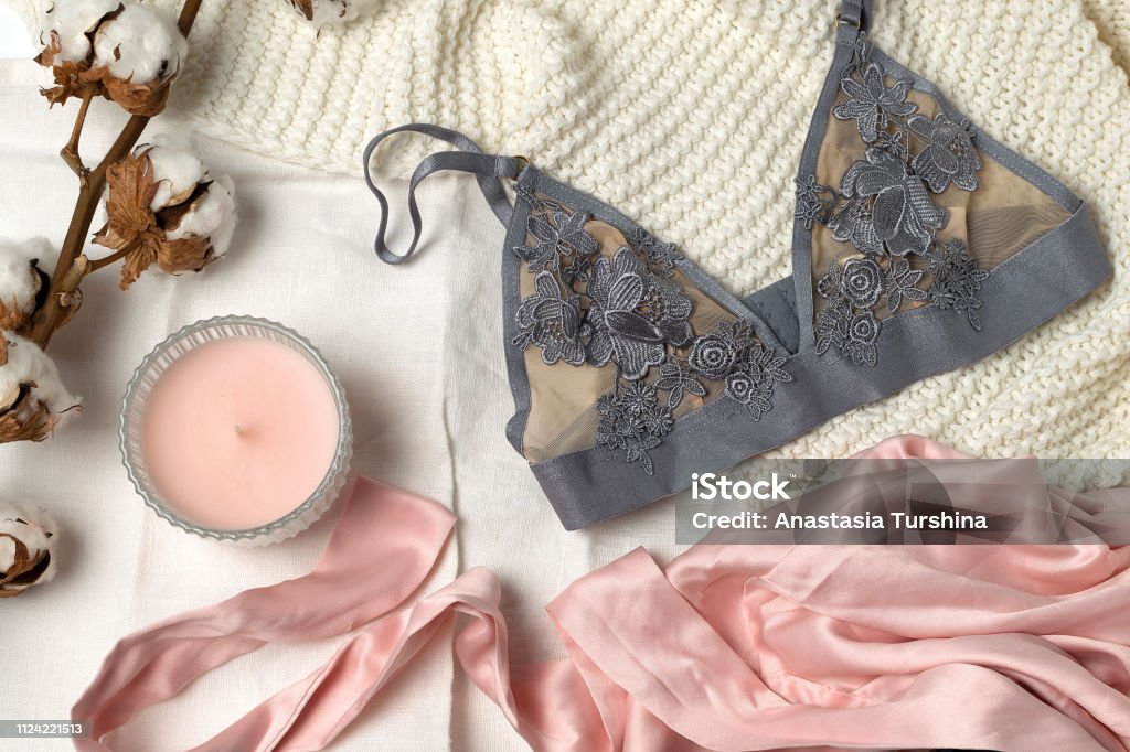 Beauty, fashion, blogger concept, social media, fashion accessories Beauty, fashion, blogger concept - lace lingerie, dried cotton flower, silk, robe, candle on white bed background, social media, fashion accessories Lingerie Stock Photo