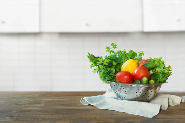 istock Modern kitchen with fresh vegetables on wooden tabletop, space for you and display products. 1124221595