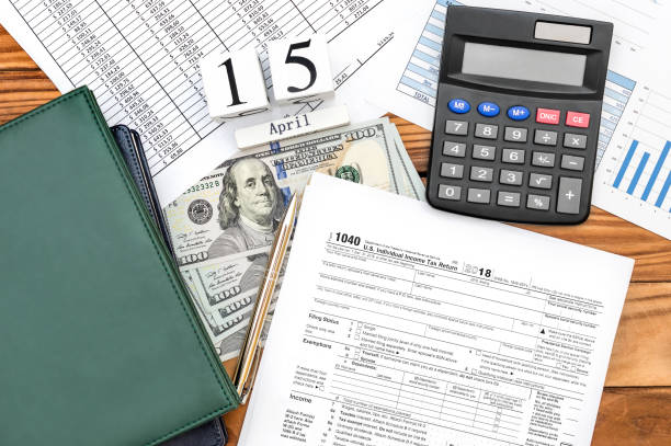 Pay tax concept. Office desk with tax forms, documents with financial, money and cubes with date of 15 april. Pay tax concept. Office desk with tax forms, documents with financial, money and cubes with date of 15 april. section 125 tax stock pictures, royalty-free photos  images