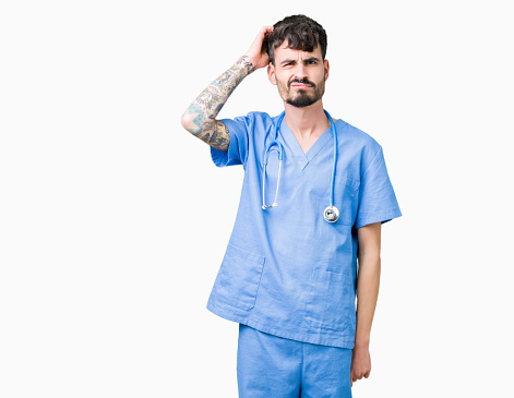 Young handsome nurse man wearing surgeon uniform over isolated background confuse and wonder about question. Uncertain with doubt, thinking with hand on head. Pensive concept.