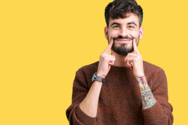istock Young handsome man wearing winter sweater over isolated background Smiling with open mouth, fingers pointing and forcing cheerful smile 1124223566