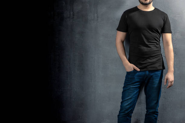 Young healthy man with black T-shirt on concrete background with copyspace for your text stock photo