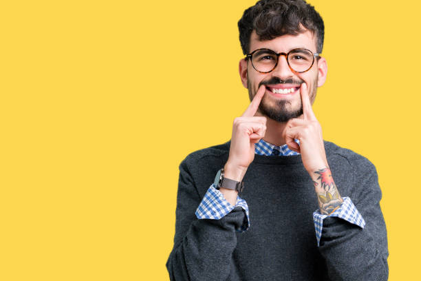 istock Young handsome smart man wearing glasses over isolated background Smiling with open mouth, fingers pointing and forcing cheerful smile 1124223790