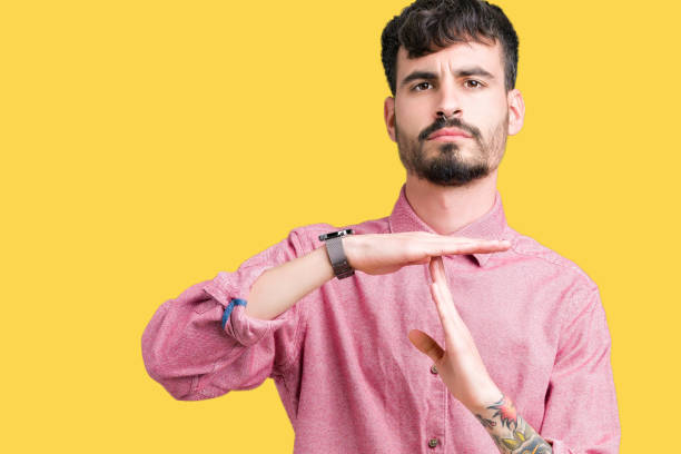 istock Young handsome man wearing pink shirt over isolated background Doing time out gesture with hands, frustrated and serious face 1124223969