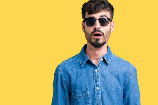 istock Young handsome man wearing sunglasses over isolated background afraid and shocked with surprise expression, fear and excited face. 1124224000