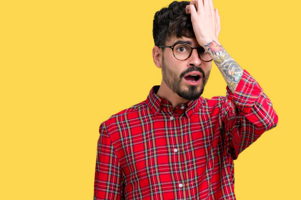 istock Young handsome man wearing glasses over isolated background surprised with hand on head for mistake, remember error. Forgot, bad memory concept. 1124224458