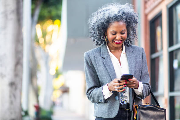 istock Mature Black Woman Texting While Walking in City 1124225710