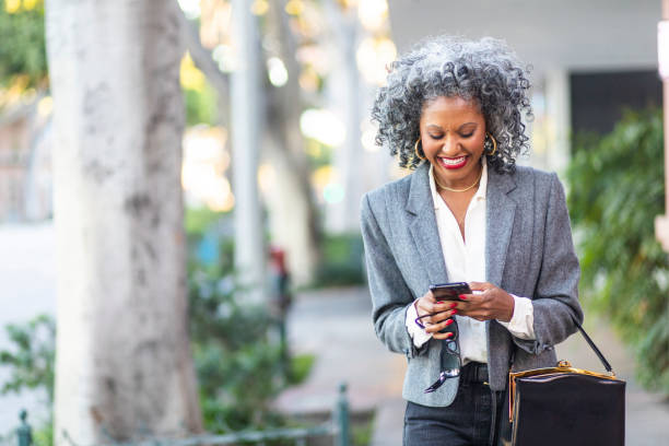 istock Mature Black Woman Texting While Walking in City 1124225767
