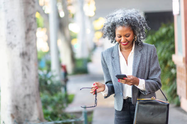 istock Mature Black Woman Texting While Walking in City 1124225771