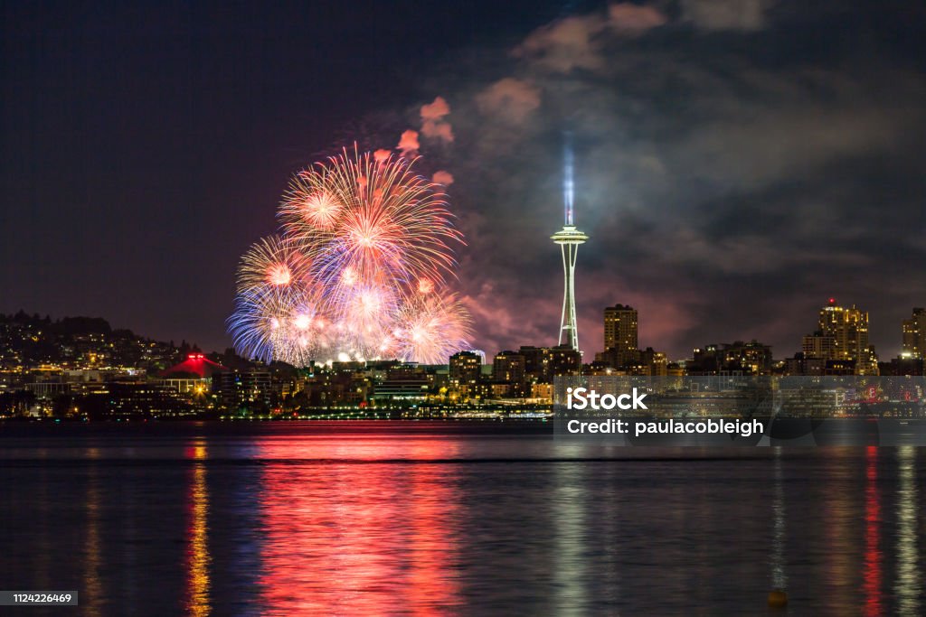 Lake Union 4th of July Fireworks and the Seattle skyline, as seen from across Elliott Bay at Seacrest Park in West Seattle, WA, USA Firework Display Stock Photo