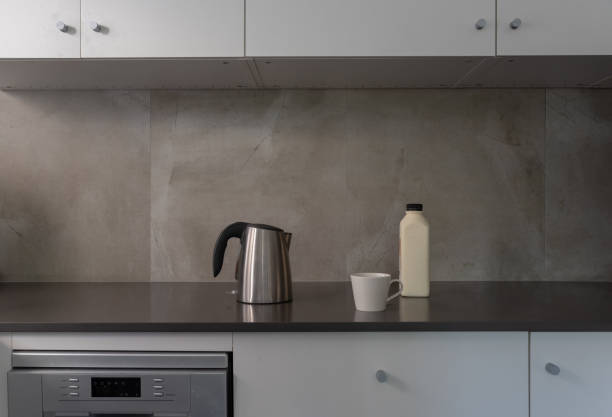 istock Kettle with up and milk on dark grey kitchen bench 1124226627