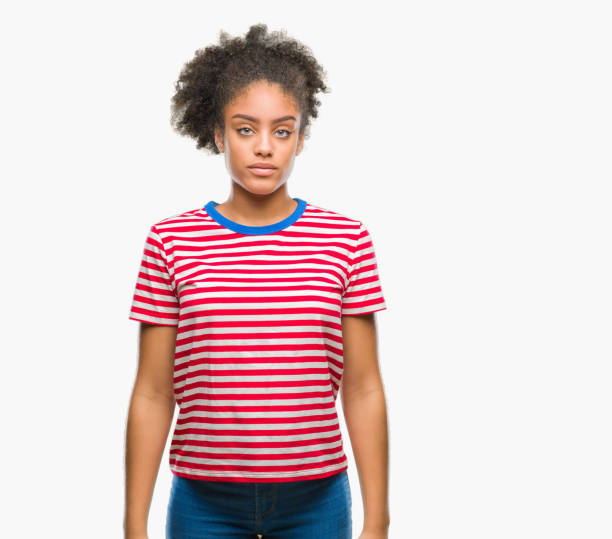 istock Young afro american woman over isolated background with serious expression on face. Simple and natural looking at the camera. 1124228698