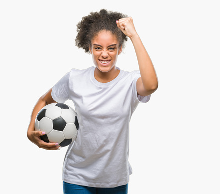 Young beautiful afro american holding soccer football ball over isolated background annoyed and frustrated shouting with anger, crazy and yelling with raised hand, anger concept