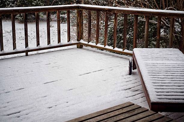 istock Snow falling on wood deck and lawn furniture 1124231490