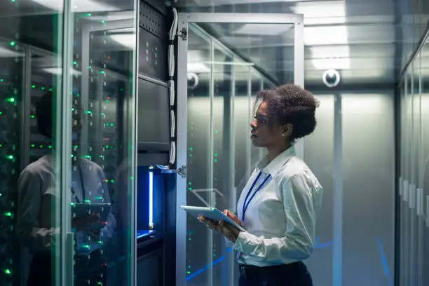 Photo of Female technician works on a tablet in a data center