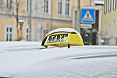 Yellow taxi roof sign covered with snow