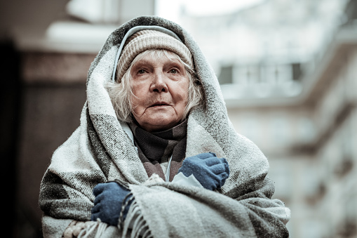 Feeling cold. Portrait of a cheerless aged woman while feeling cold