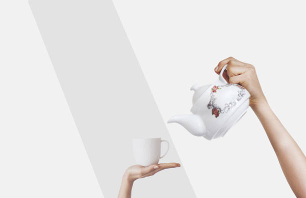 istock Hands holding kettle on isolated background and teacup 1124240462